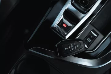 a close up shot of a car key and an electronic handbrake